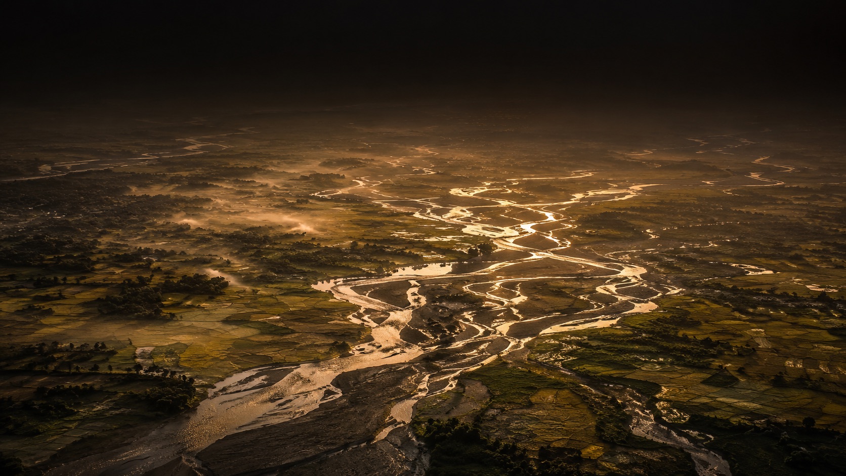 Aerial view of North Bengal's braided river delta and paddy fields at first light